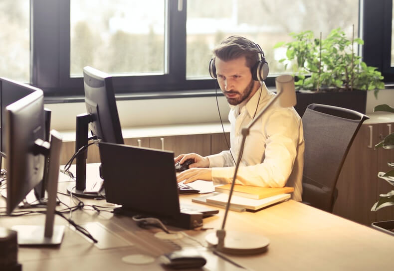 man working on a laptop and talking